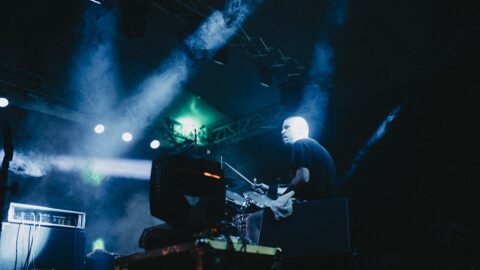 1280px Drummer performs energetically on stage with vibrant lights in a lively concert setting during the night