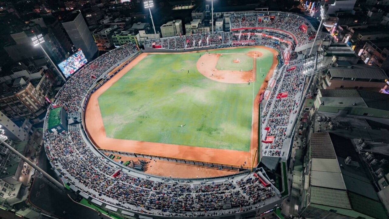 A packed baseball stadium lit up at night