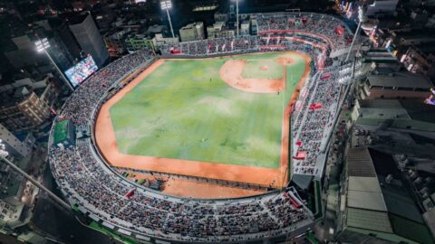 A packed baseball stadium lit up at night