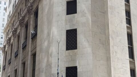 Facade of the New York Stock Exchange building with American flags