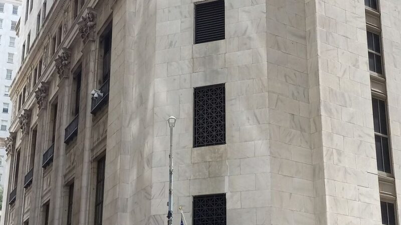 Facade of the New York Stock Exchange building with American flags